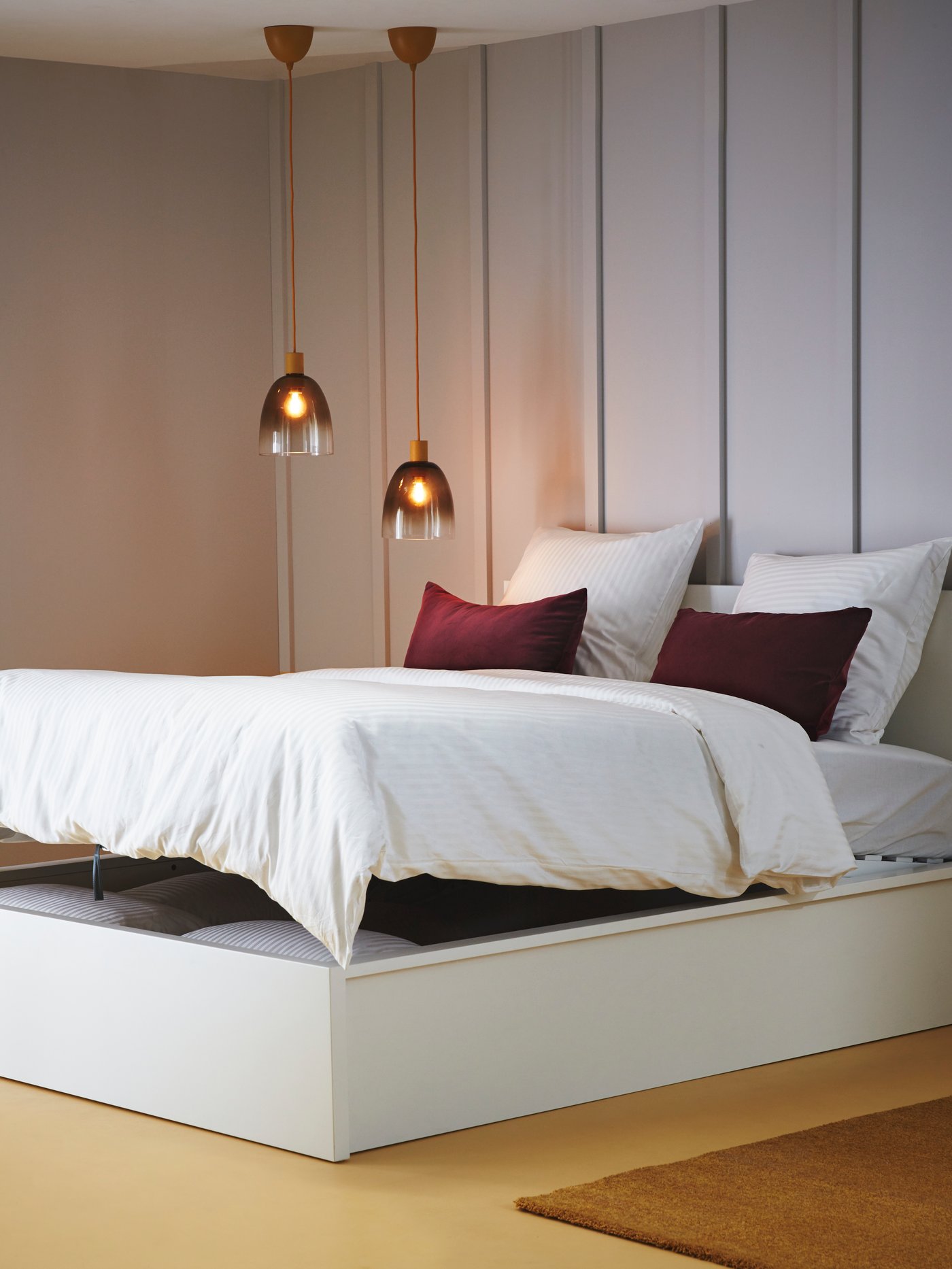 Una habitación con una cama doble con base de cama blanca.