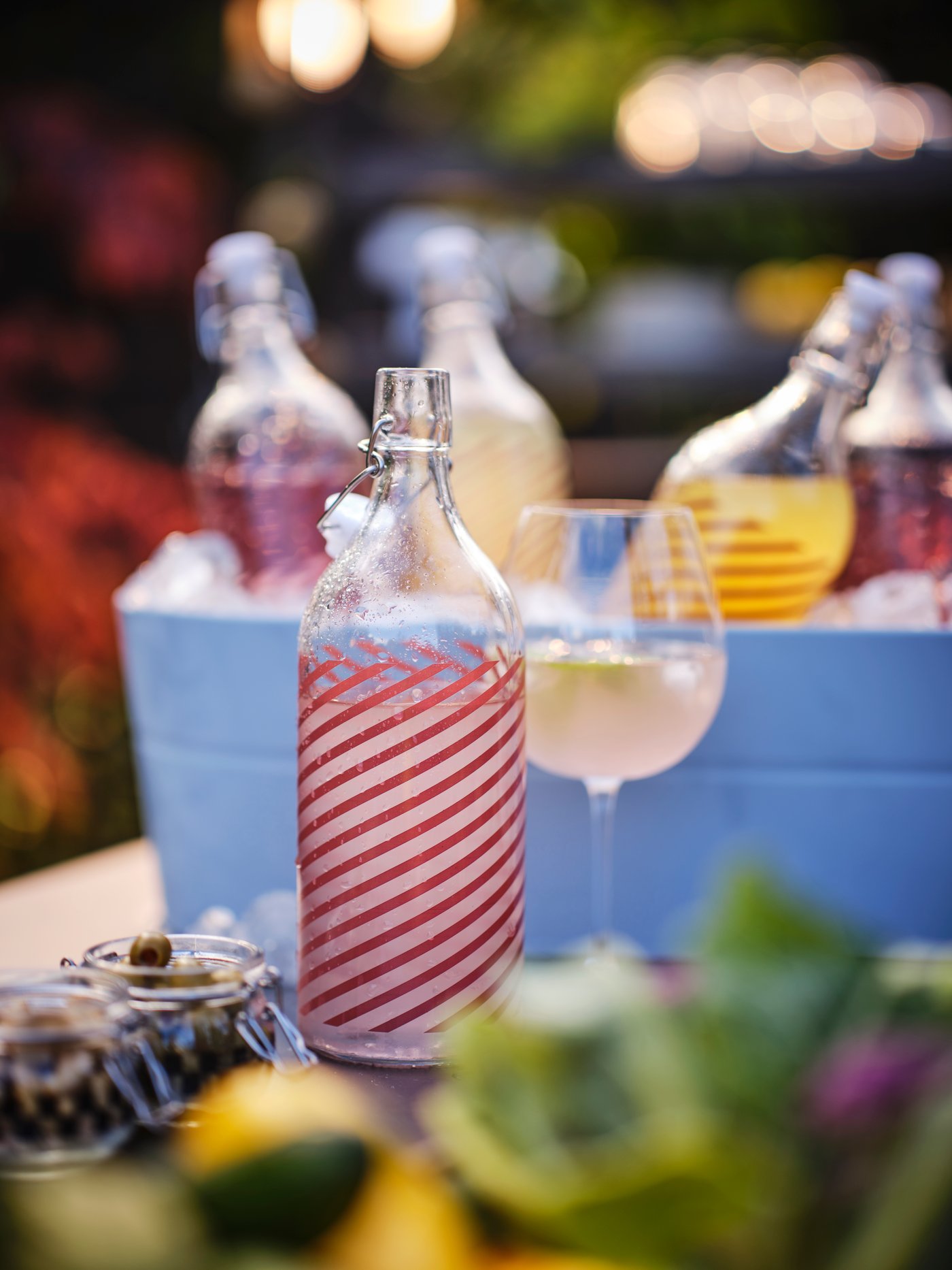 A glass KORKEN bottle with stopper with a red pattern.