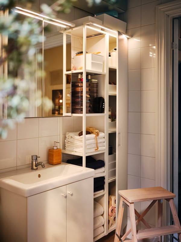 Un estante de baño ENHET blanco con cosas organizadas en los entrepaños.