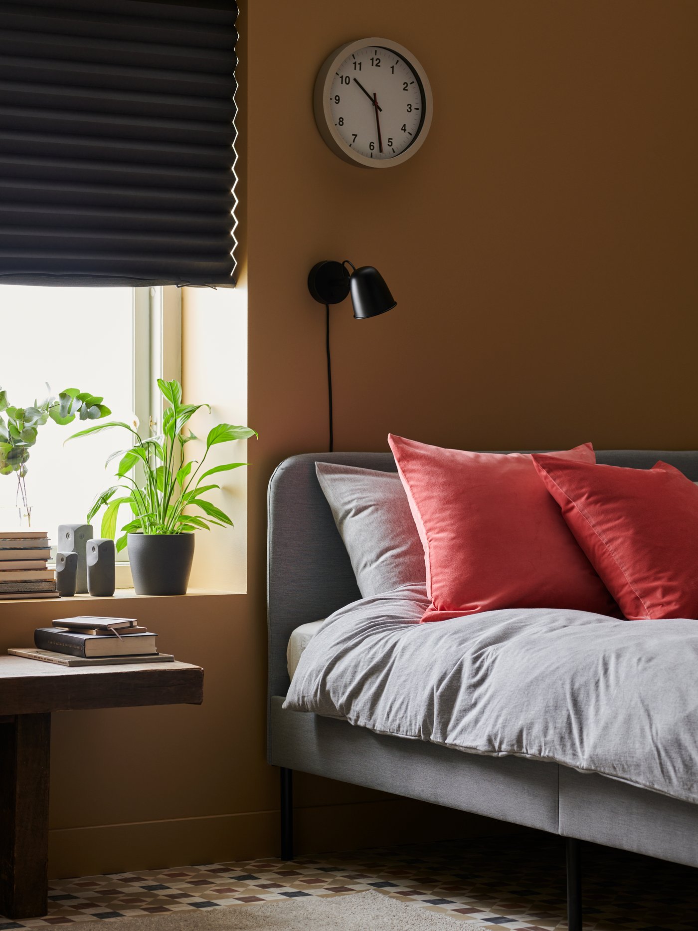 A black SKURUP wall lamp in the bedroom