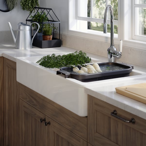 IKEA Küchenlösung mit HAVSEN Waschbecken, INSJÖN Wasserhan, KASKER Arbeitsplatte in einem Marmor design und ENKÖPING Küchenfronten in einem dünklerem Holz gehalten.