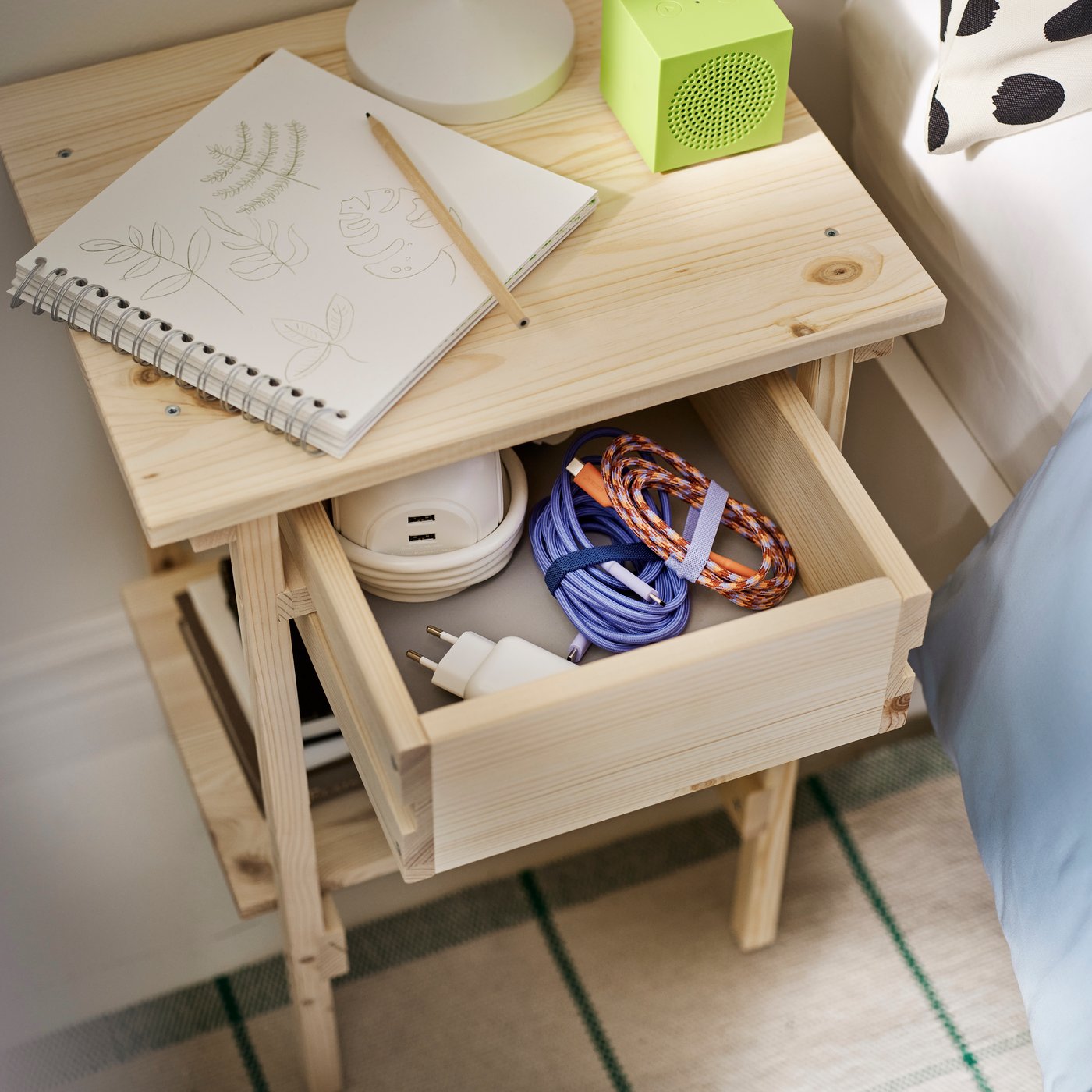 A bedside table drawer partly open revealing the LILLHULT N3 USB-C to USB-C cable along with small items.