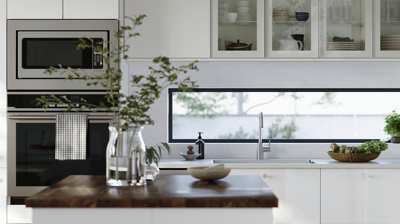 A kitchen with high-gloss RINGHULT fronts and wall cabinets with HEJSTA glass doors has a kitchen island in the foreground.