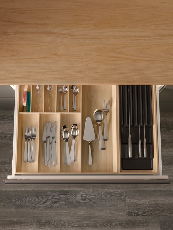 A kitchen drawer is open, cutlery and knives are neatly placed in UPPDATERA cutlery and knife trays in light bamboo.