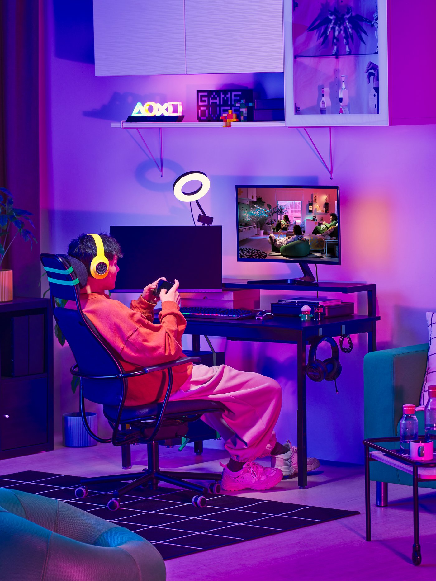 A boy is playing in a blue-lit room at a desk.
