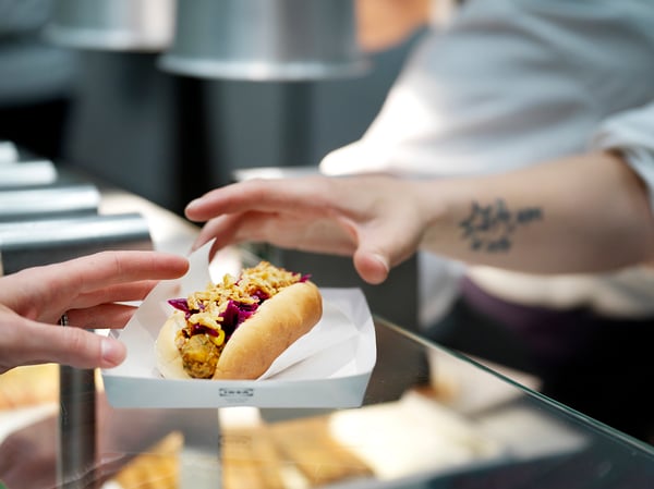 To unge kvinder spiser en veggie hotdog.