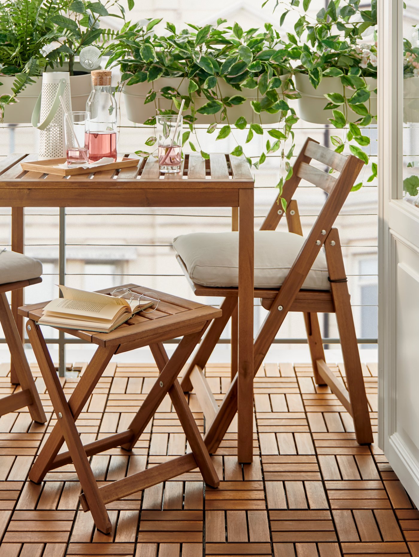 Una terraza pequeña con muebles de exterior NÄMMARÖ de madera.