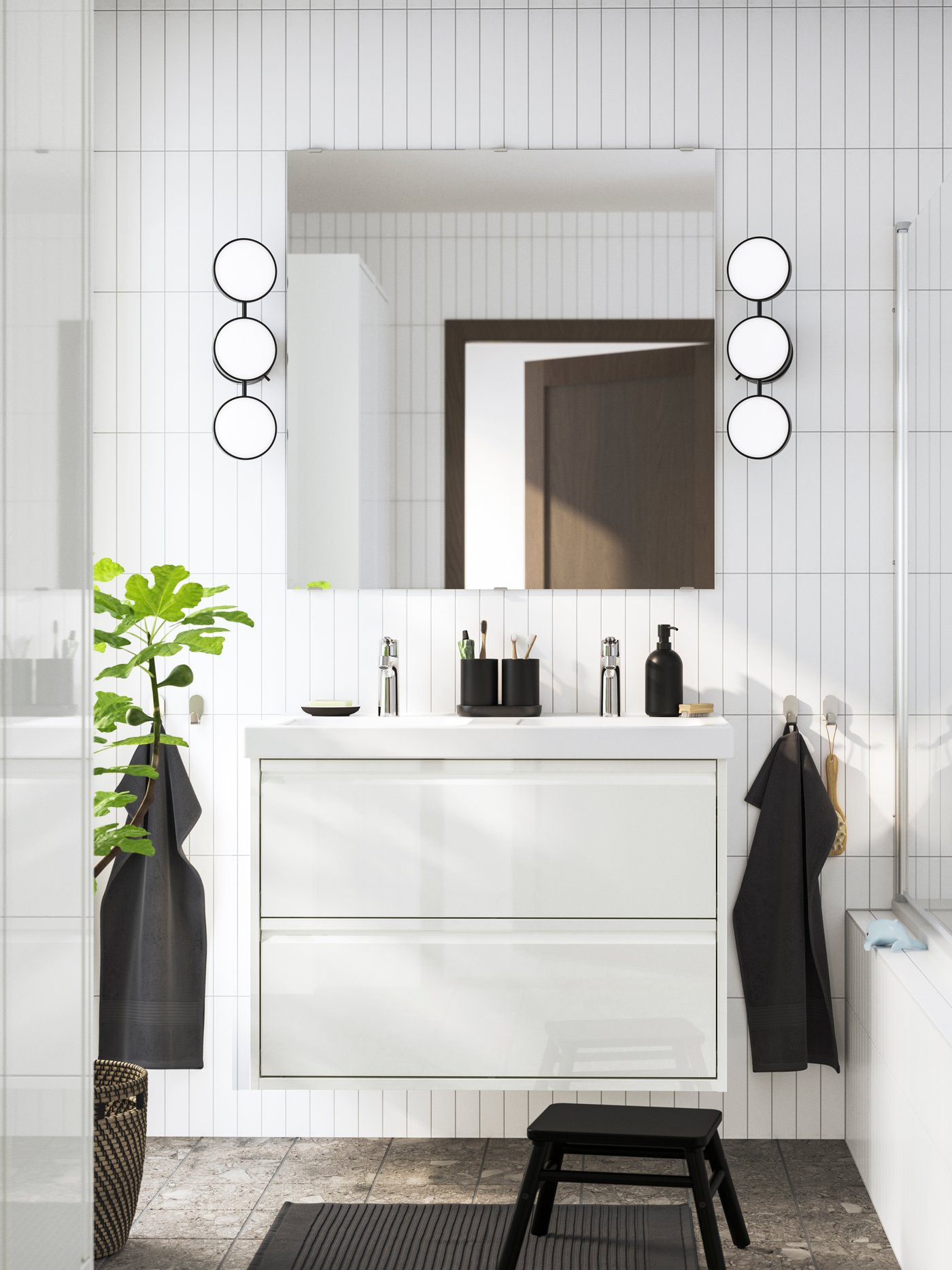Modern white bathroom with a floating vanity, round wall lights and a glass‑panel bathtub.