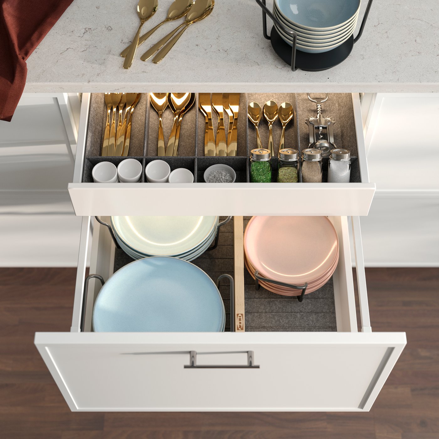 An opened kitchen drawer showing a grey UPPDATERA adjustable organiser filled with cutlery, utensils and spice jars.