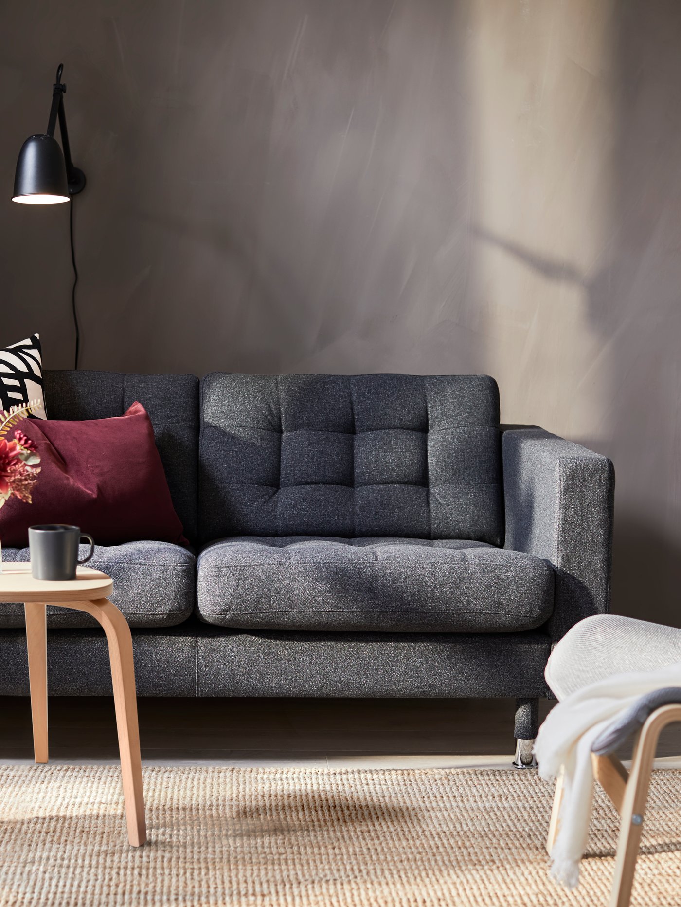 A grey LANDSKRONA sofa with birch KYRRE stool in the living room