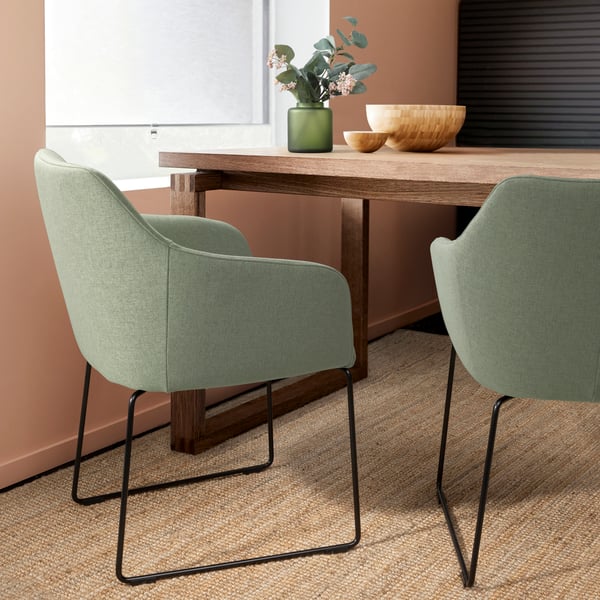 A light green TOSSBERG dining chair at a wooden dining table in the dining room.