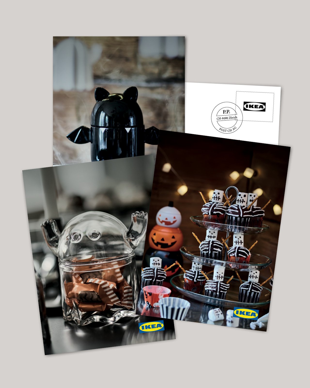 Halloween display featuring black and glass containers and spooky cupcakes arranged on a festive table.