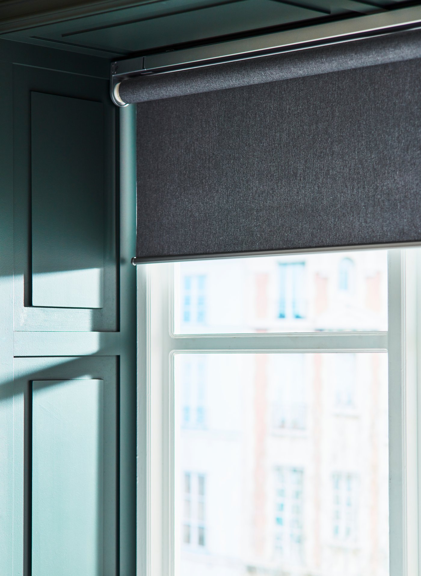 Store à enrouleur opaque FYRTUR gris intelligent sans fil/à piles dans une chambre à coucher.