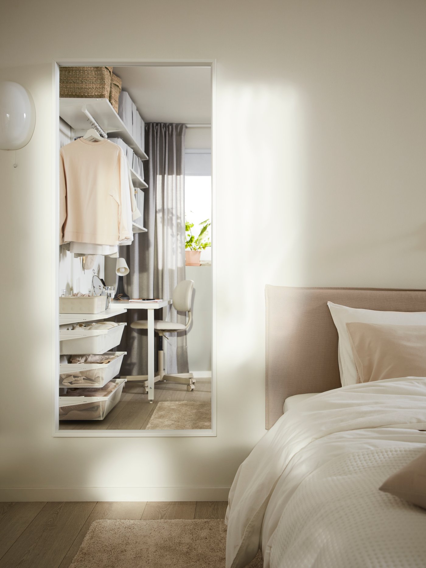 A white glass KALLBLIXT wall lamp in the bedroom