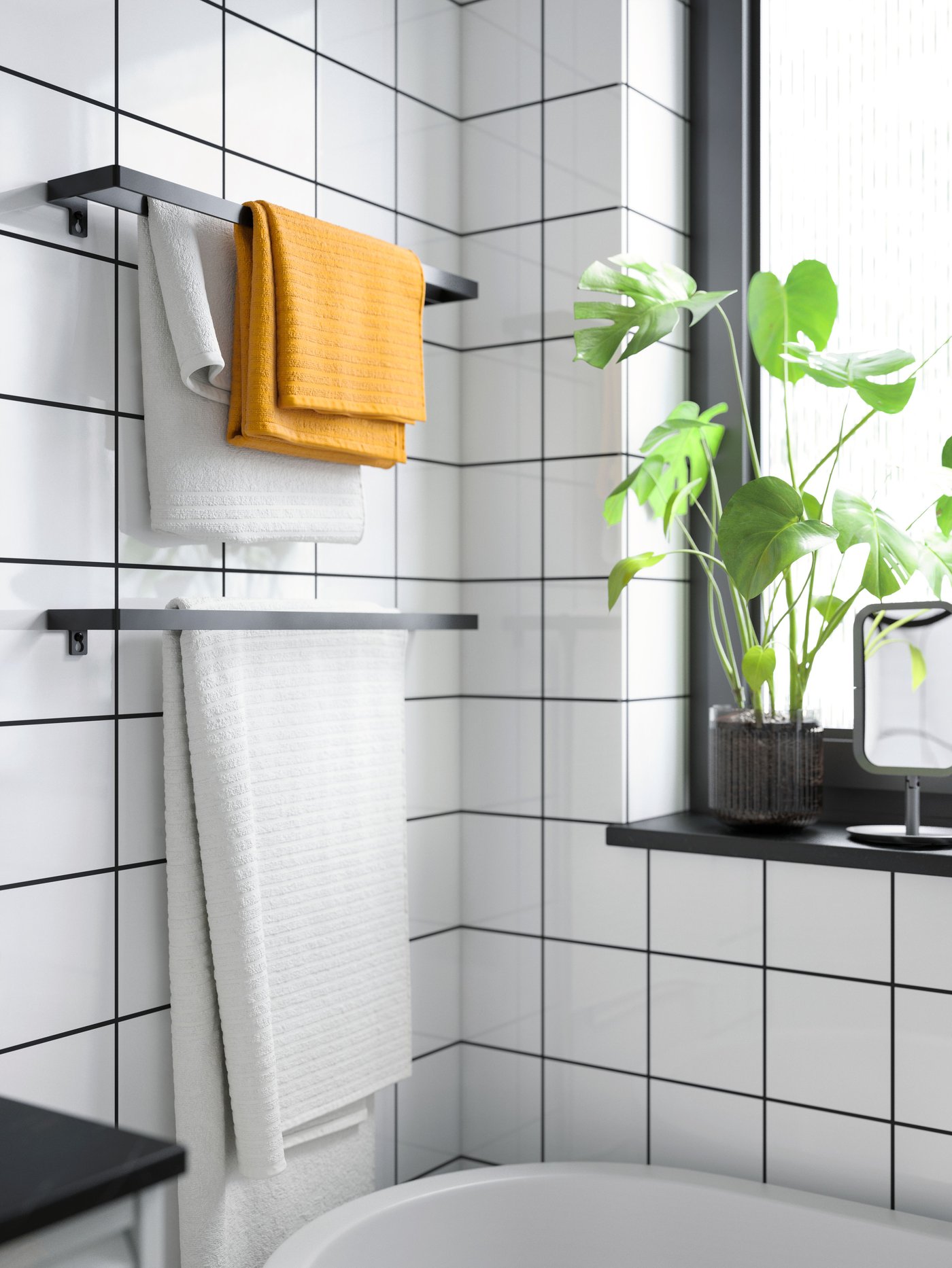 A stylish IKEA bathroom features a wooden vanity with a white vessel sink, a large round mirror, a tall wooden cabinet, dark blue tiles, and towels beside a glass shower enclosure.