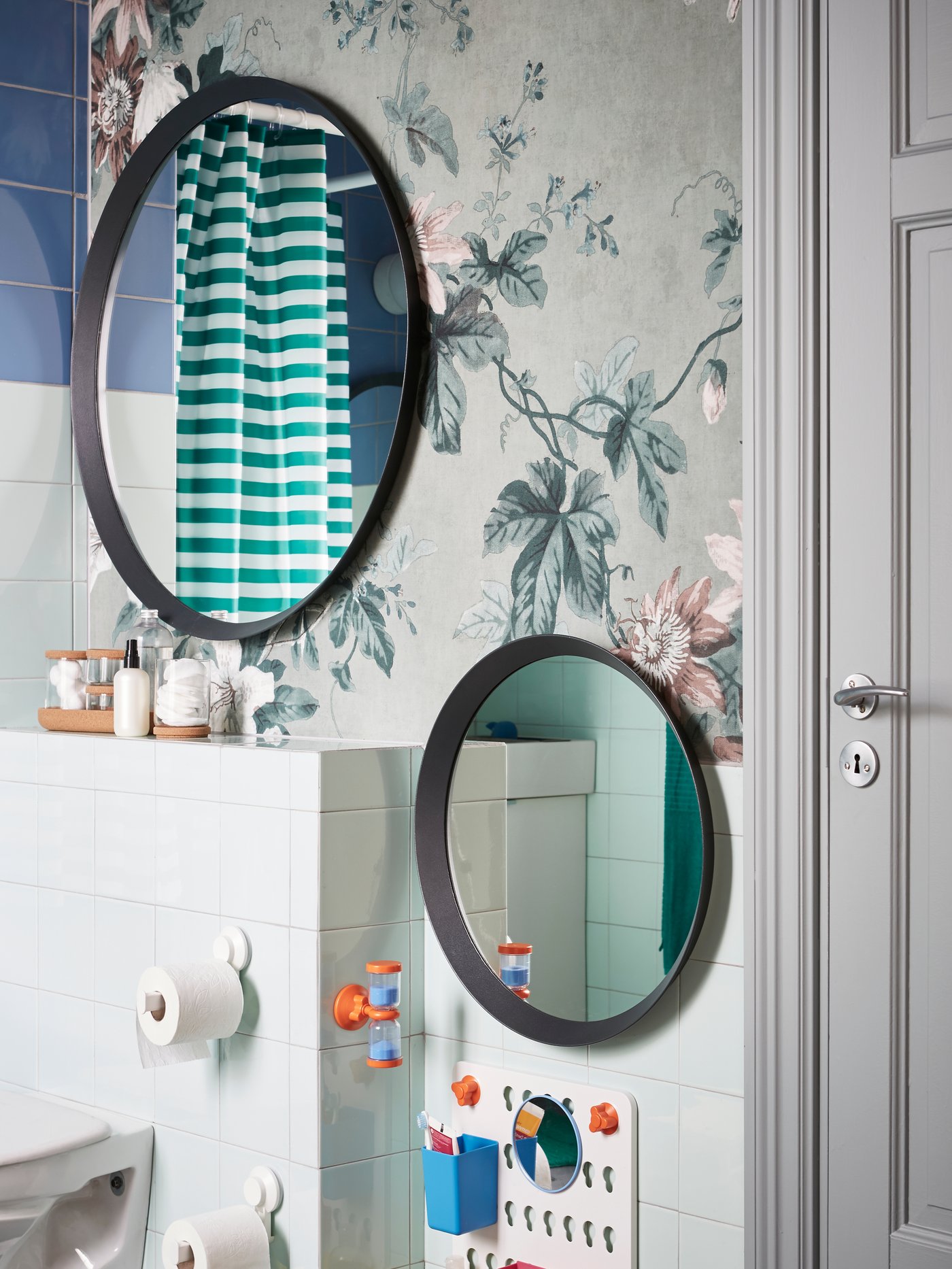 A mirror with a LEDSJÖ led wall lamp with five bulbs and a small magnifying FRÄCK mirror on the side in a green bathroom.