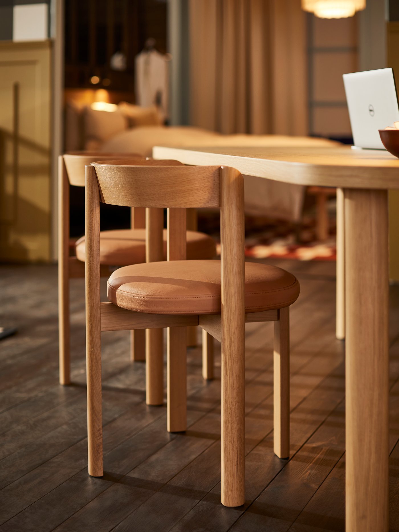 Une chaise STOCKHOLM 2025 chêne/cuir posée à une table.
