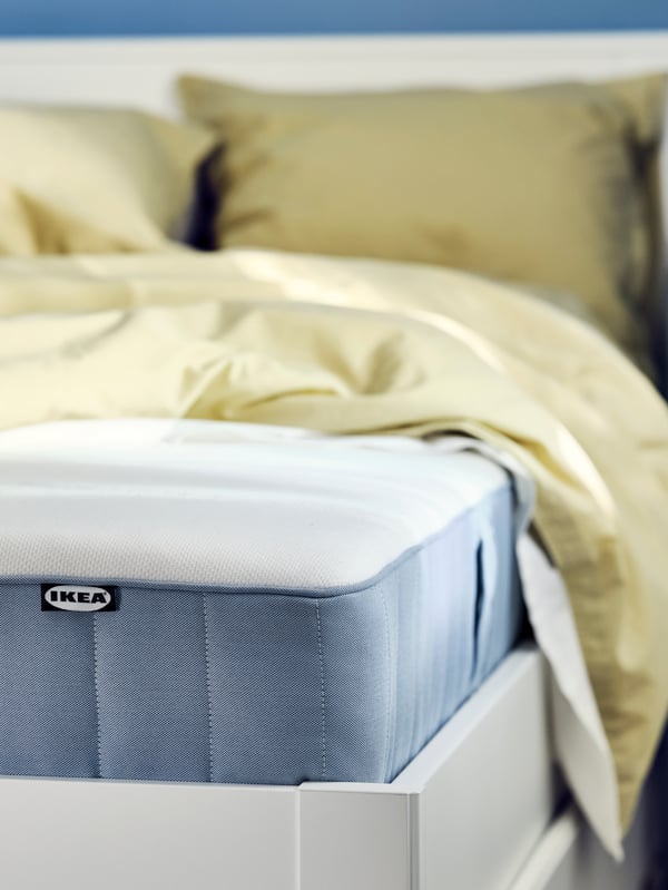 A firm/light blue VESTERÖY pocket sprung mattress in the bedroom