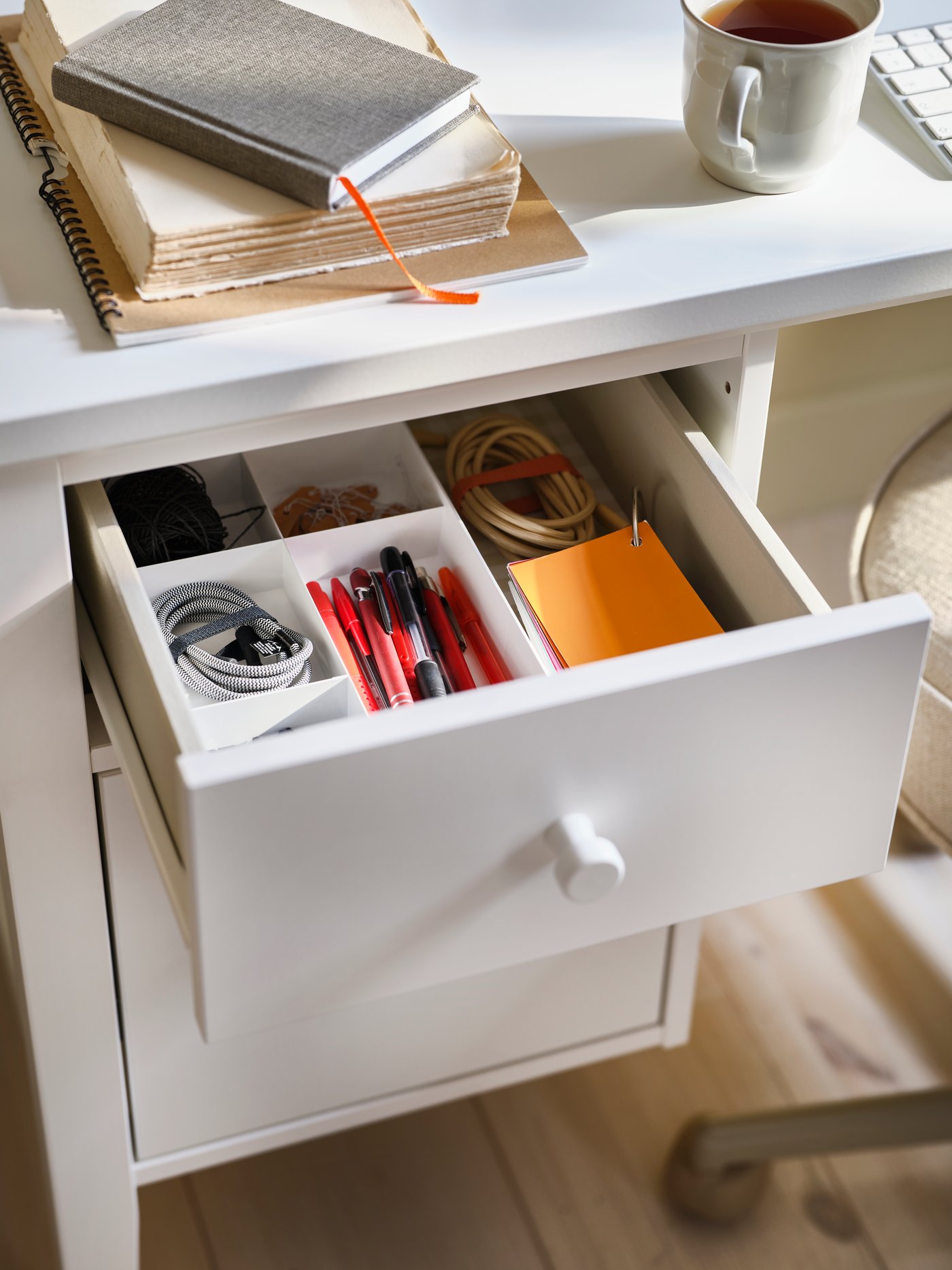 A white GULLABERG desk with a drop-file drawer unit, the top drawer open to reveal neatly arranged accessories.