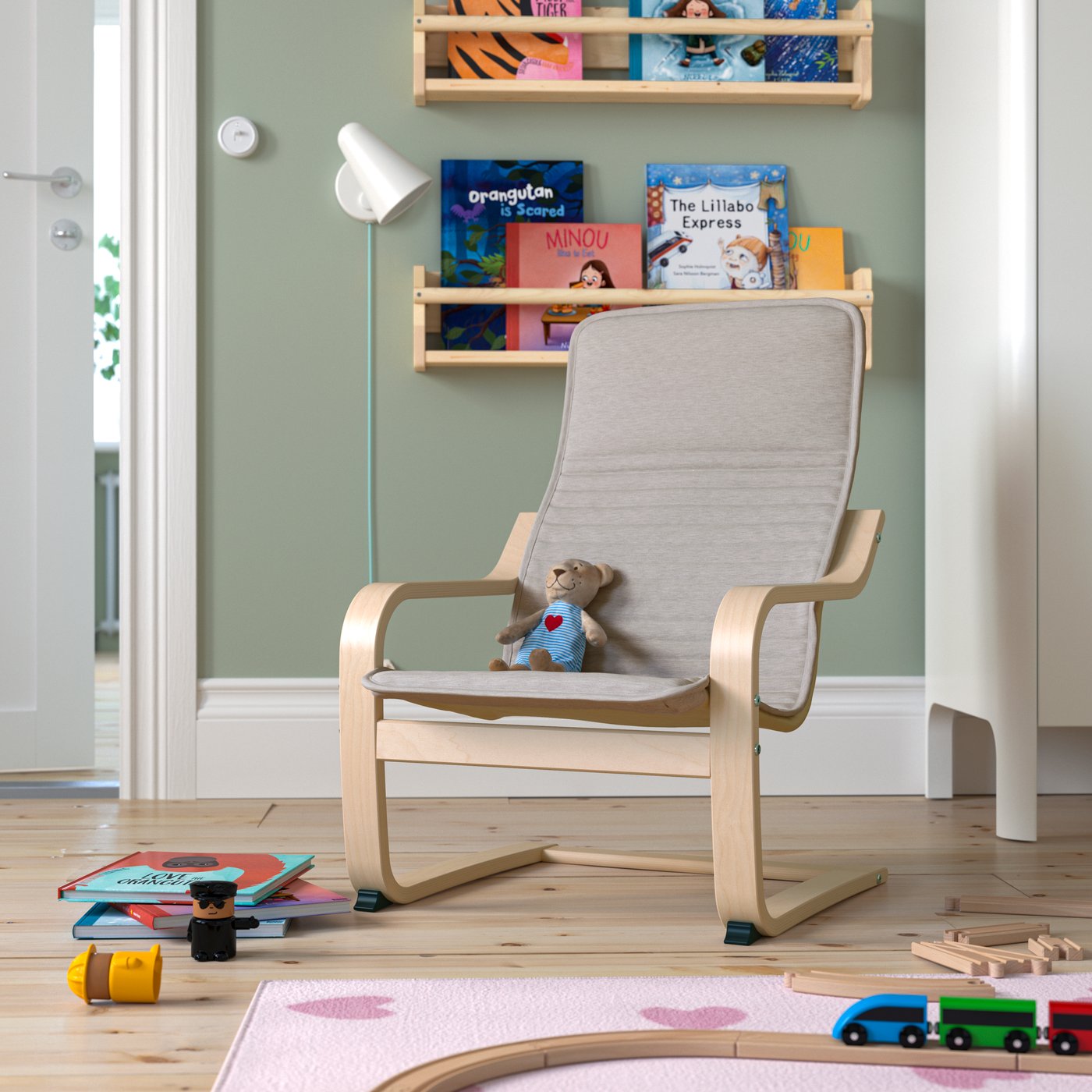 Ein POÄNG Kindersessel in Birkenfurnier mit dem Bezug Knisa Hellbeige im Kinderzimmer.