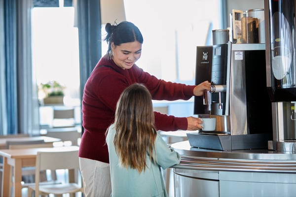 A woman is pouring coffee into a mug.