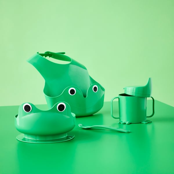 Service pour bébé MATA composé de quatre pièces vert vif sur le thème des grenouilles, avec bavoir, bol, gobelet et cuillère.