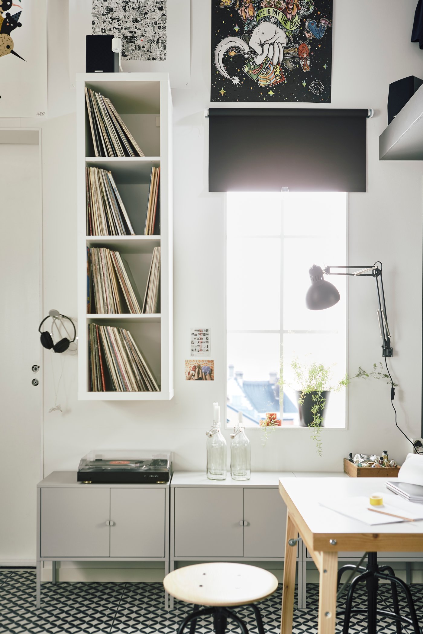 Estante KALLAX blanco junto a una ventana, con discos de vinilo en sus repisas interiores.