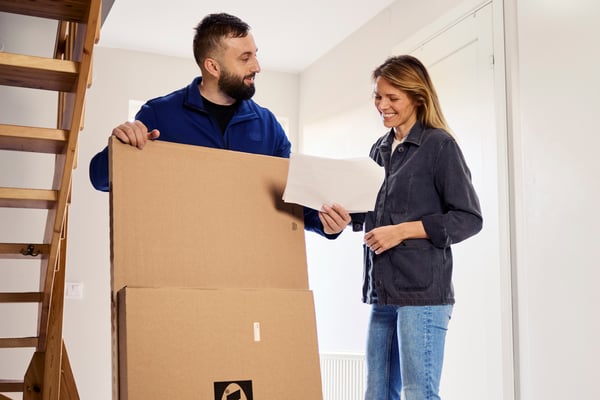 Ein IKEA Mitarbeiter übergibt eine Lieferung an eine Kundin