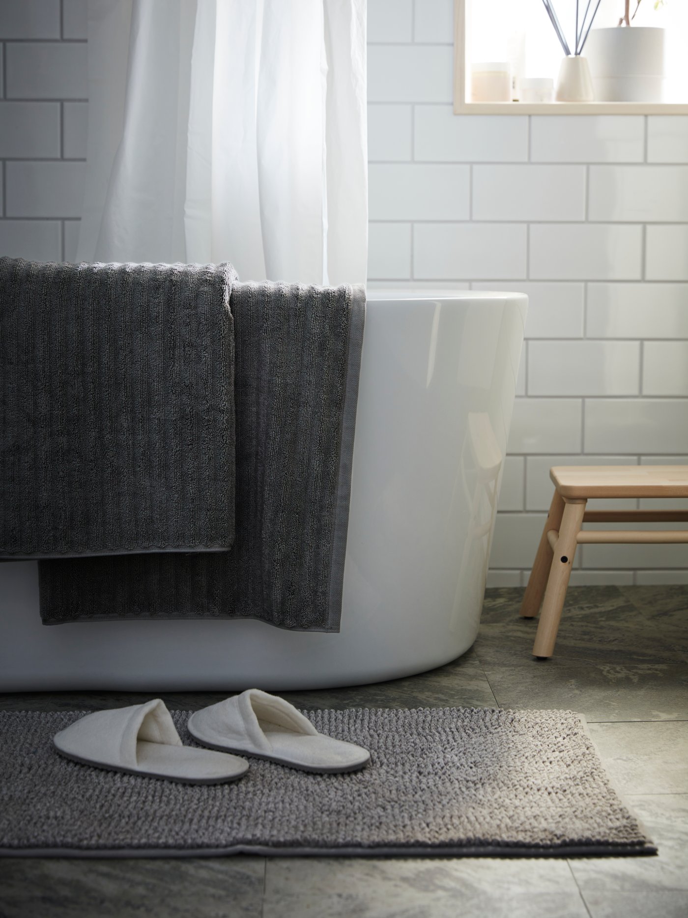 A white TÅSJÖN slippers in the bathroom