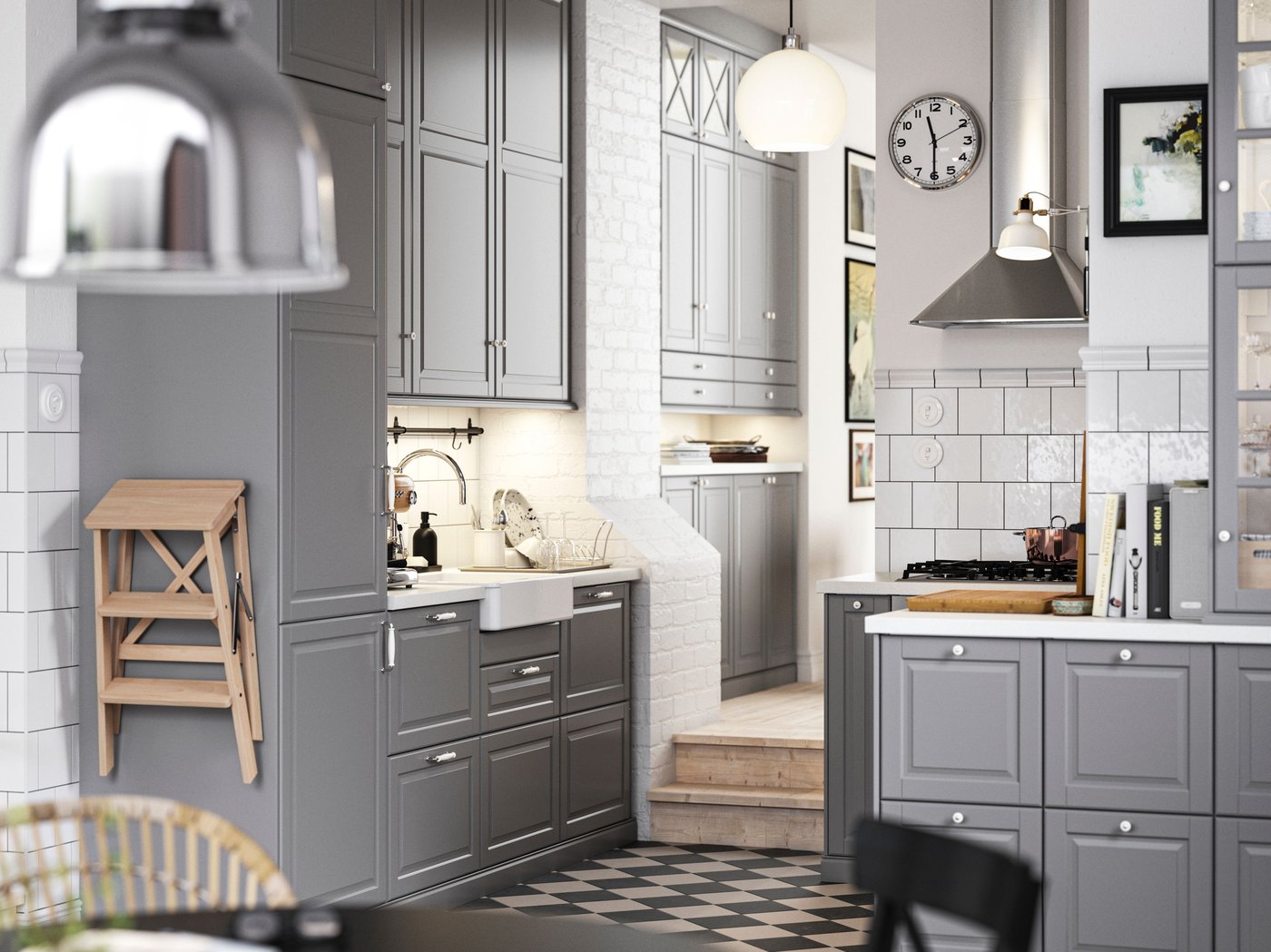 A traditional kitchen with a chequered floor, grey BODBYN kitchen fronts and white/light grey stone effect/laminate worktops.