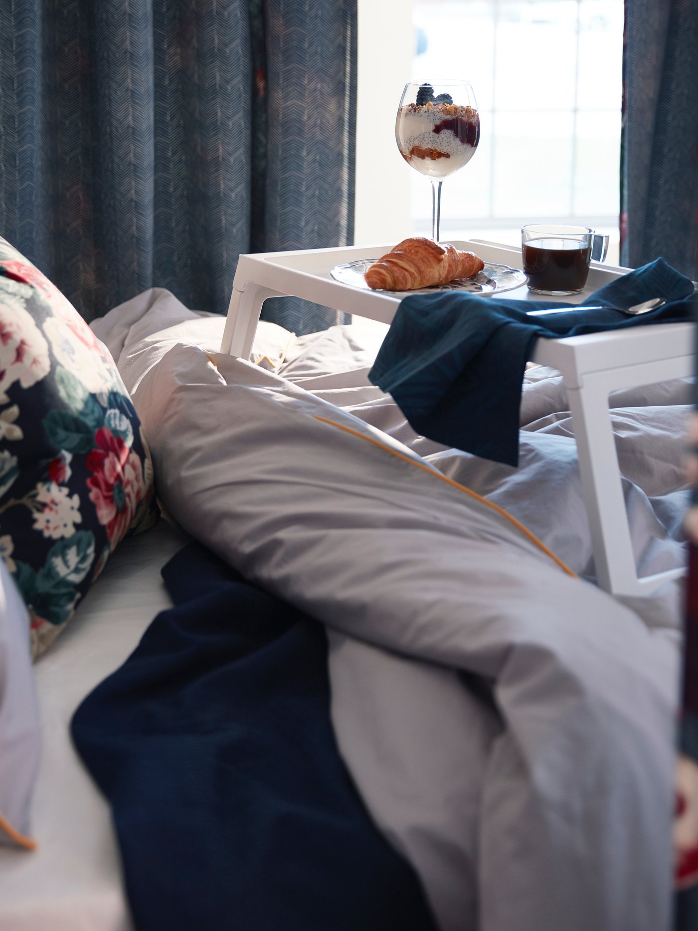 Ein VILDKAPRIFOL Geschirrtuch mit blauen Blättern im Schlafzimmer