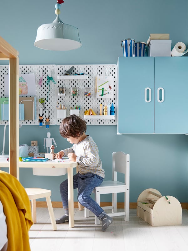 A white SKÅDIS pegboard in the childrens room