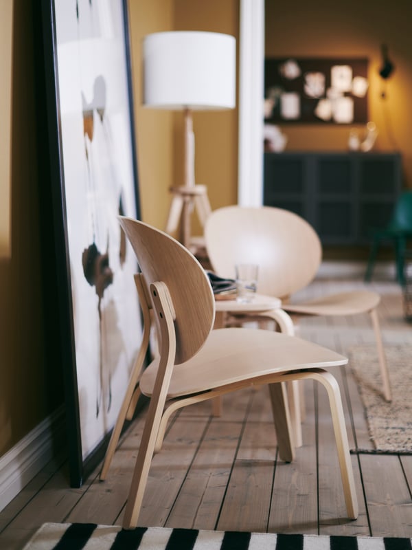 Two FRÖSET easy chairs in white stained oak veneer are paired with a KYRRE stool for a casual sitting area.