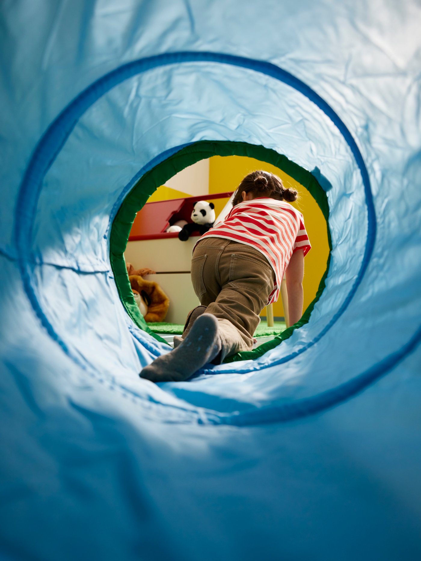 Shot taken from within blue DVÄRGMÅS play tunnel, with a child crawling out of the back end of it.