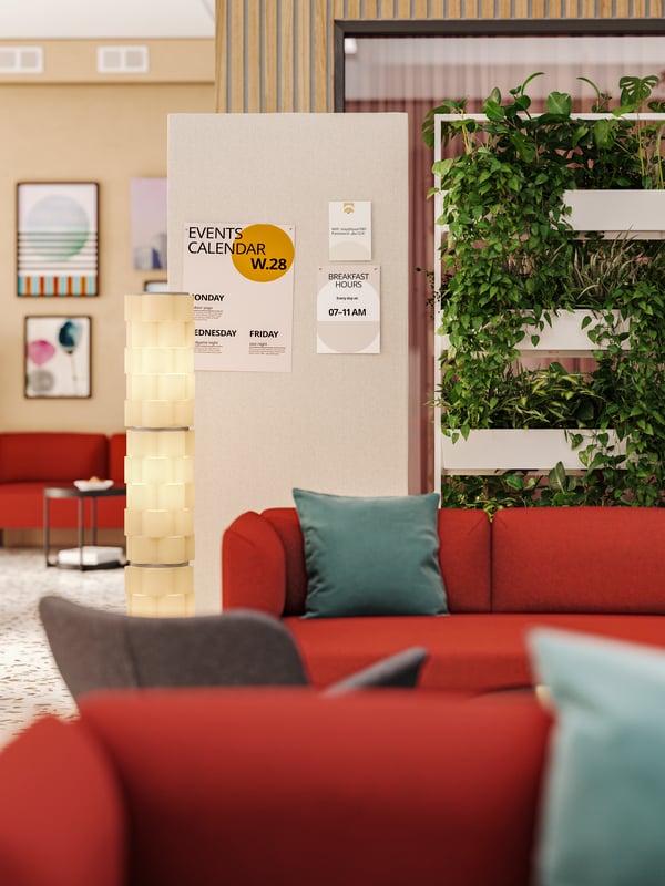 Events and info are pinnned to the acoustic screen of a MITTZON frame with castors that is behind sofa seating in a lounge.