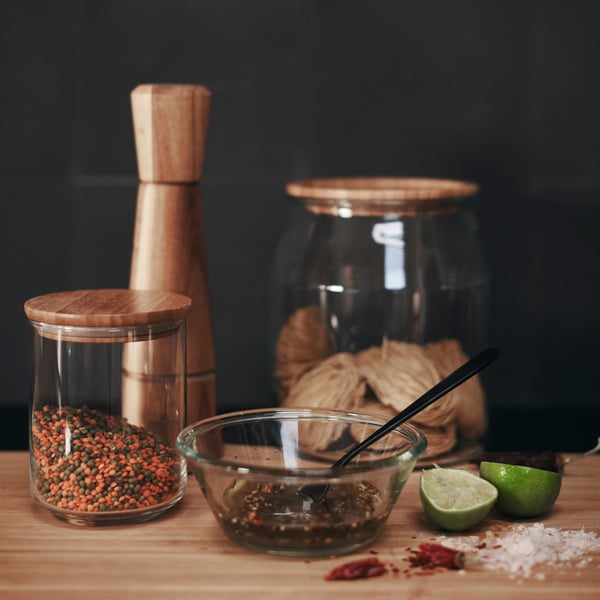 IKEA 365+ jars with lids in bamboo and of various sizes, with different contents standing on a wooden surface.