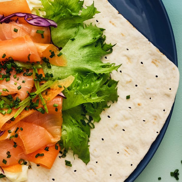 Flatbread with salmon, egg & mayonnaise on a plate.