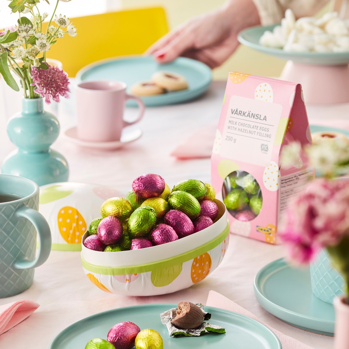 A set up table with some VÅRKÄNSLA milk chocolate eggs placed into a paper Easter egg.