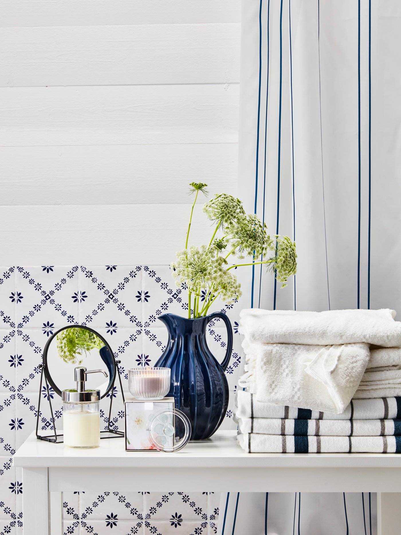 NÄRSEN towels on a table beside a VANLIGEN vase and other accessories.