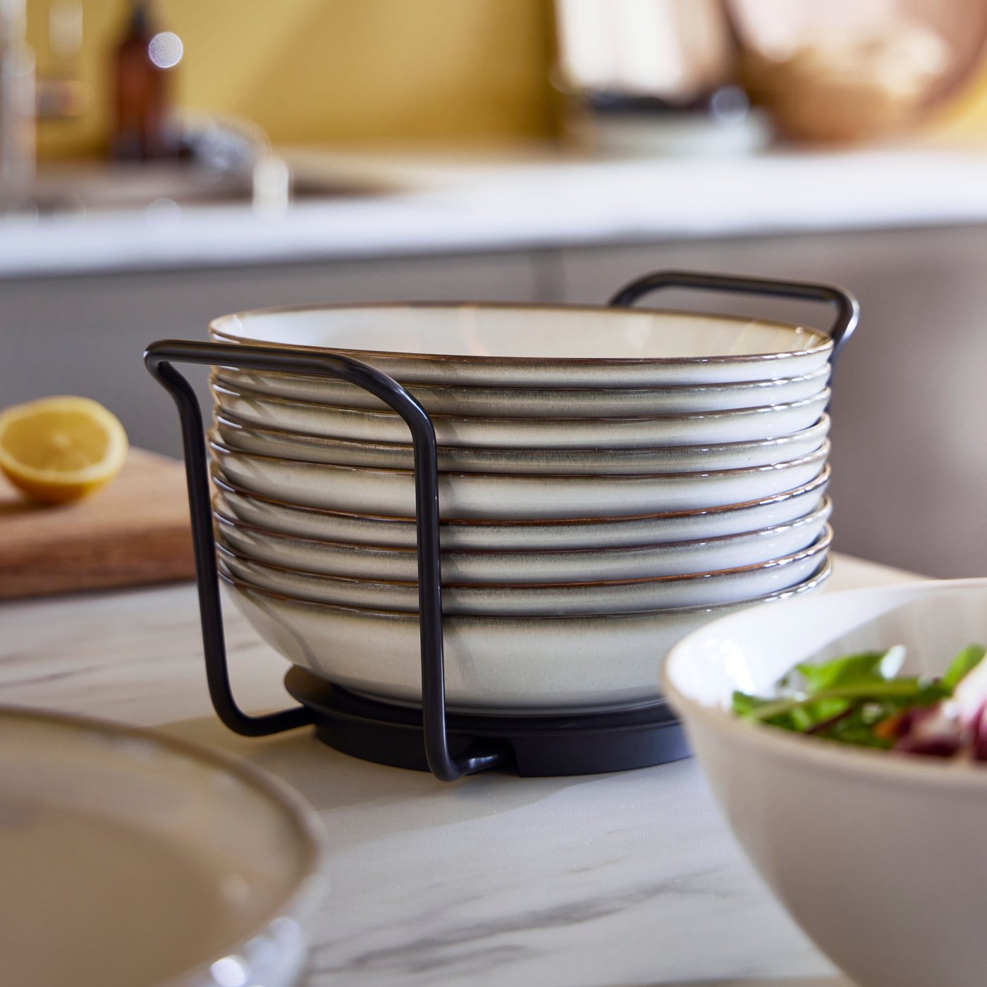 Una torre de platos ordenados en un organizador UPPDATERA sobre una cubierta de cocina.