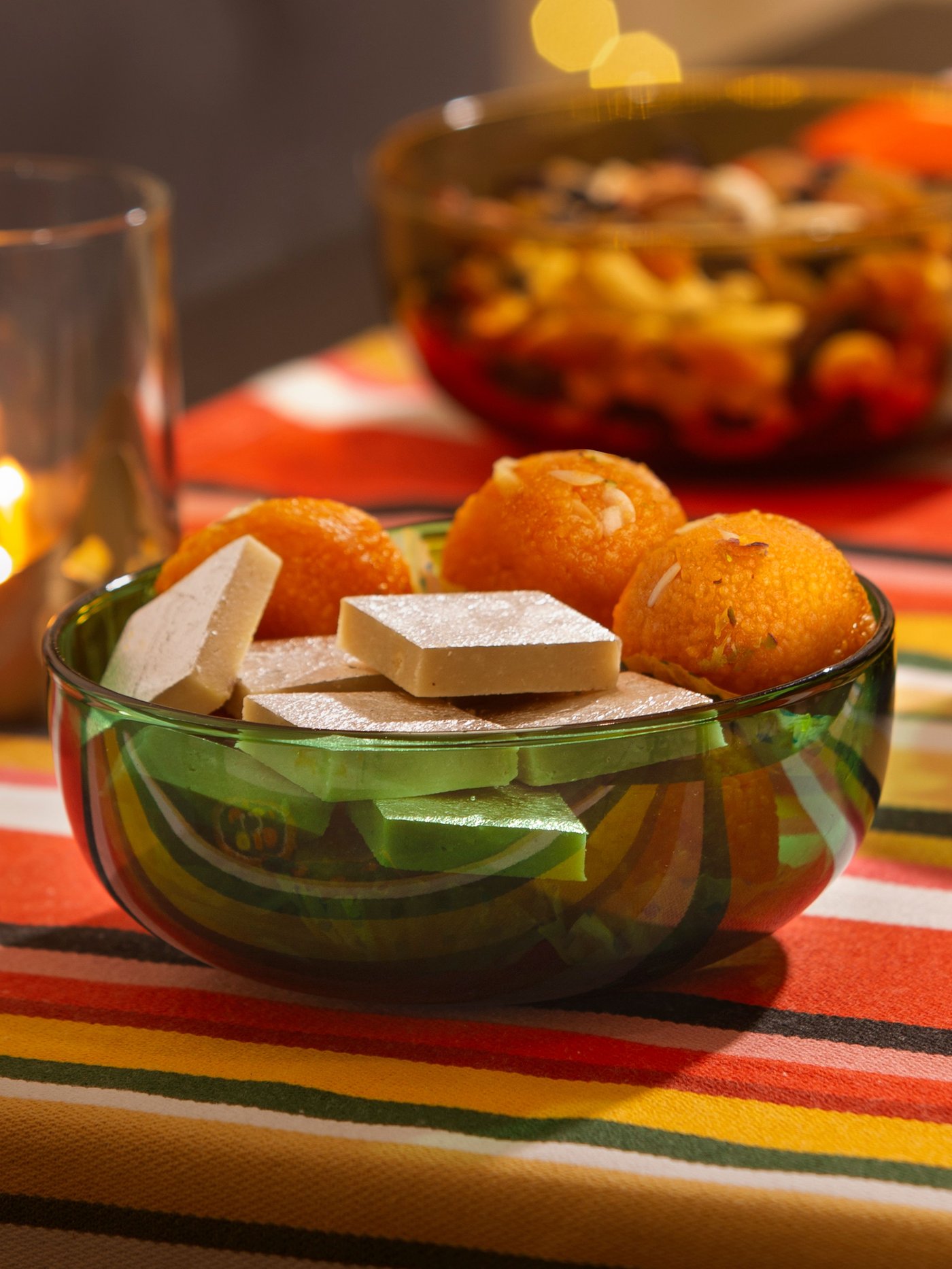 A glass/green AROMATISK serving bowl