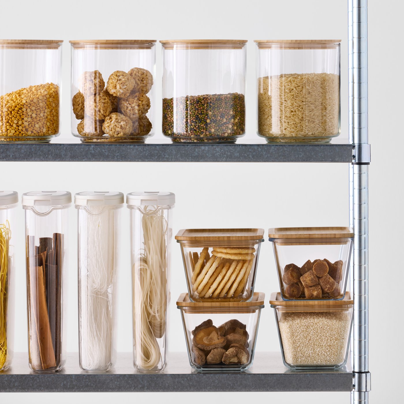 A kitchen shelf displays clear glass EKLATANT jars with bamboo lids, neatly containing various dry foods.