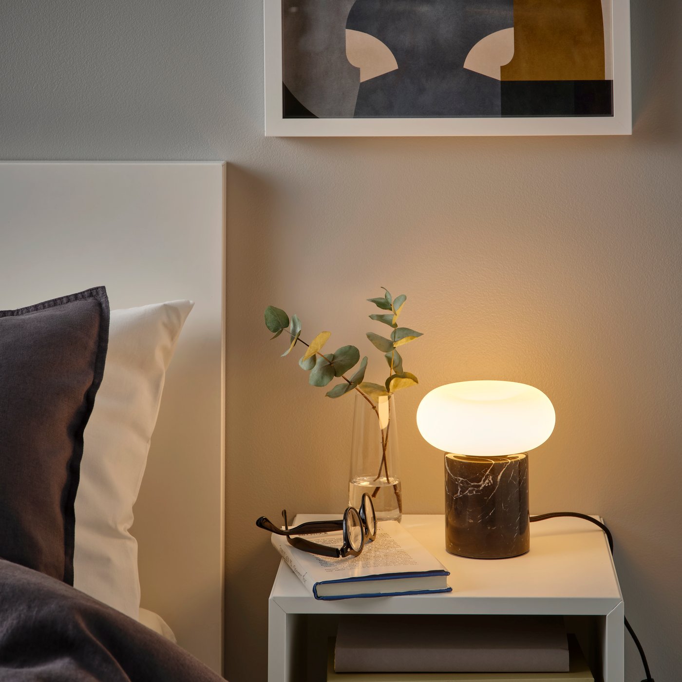 A donut-shaped opal white MOLNART LED bulb E27 120 lumen in the bedroom