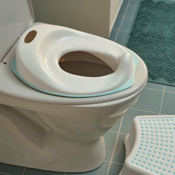 A close-up of TOSSIG toilet seat that makes toilet training easier for children, placed on top of a regular toilet.