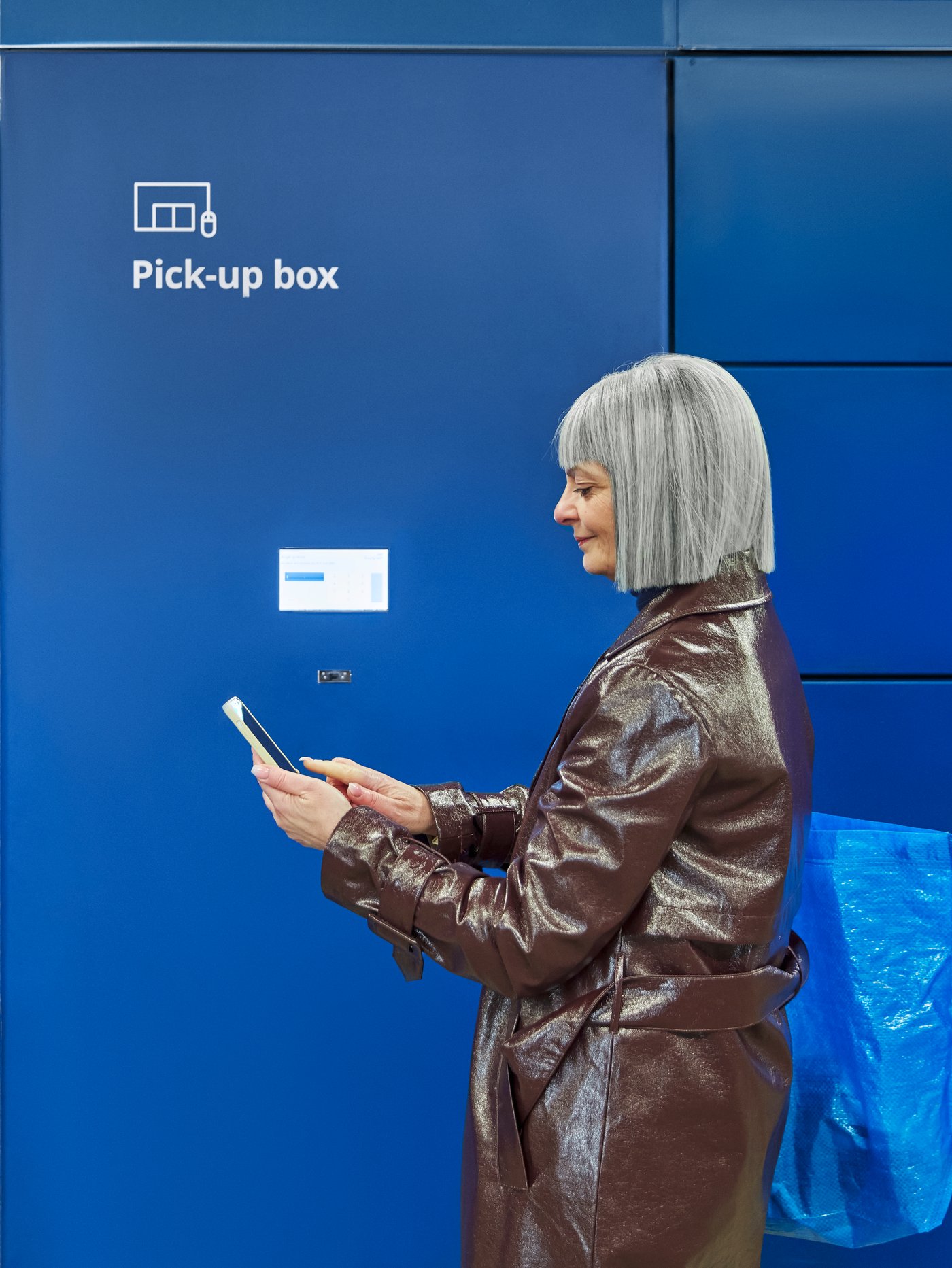 Eine Frau steht vor einer blauen IKEA Abholbox um ihre Click & Collect Bestellung abzuholen.