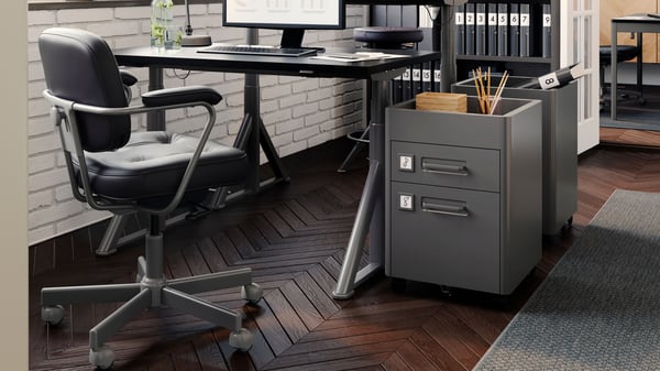 In einem hellen, modernen Büro steht ein schwarzer ALEFJÄLL Drehstuhl an einem Schreibtisch.