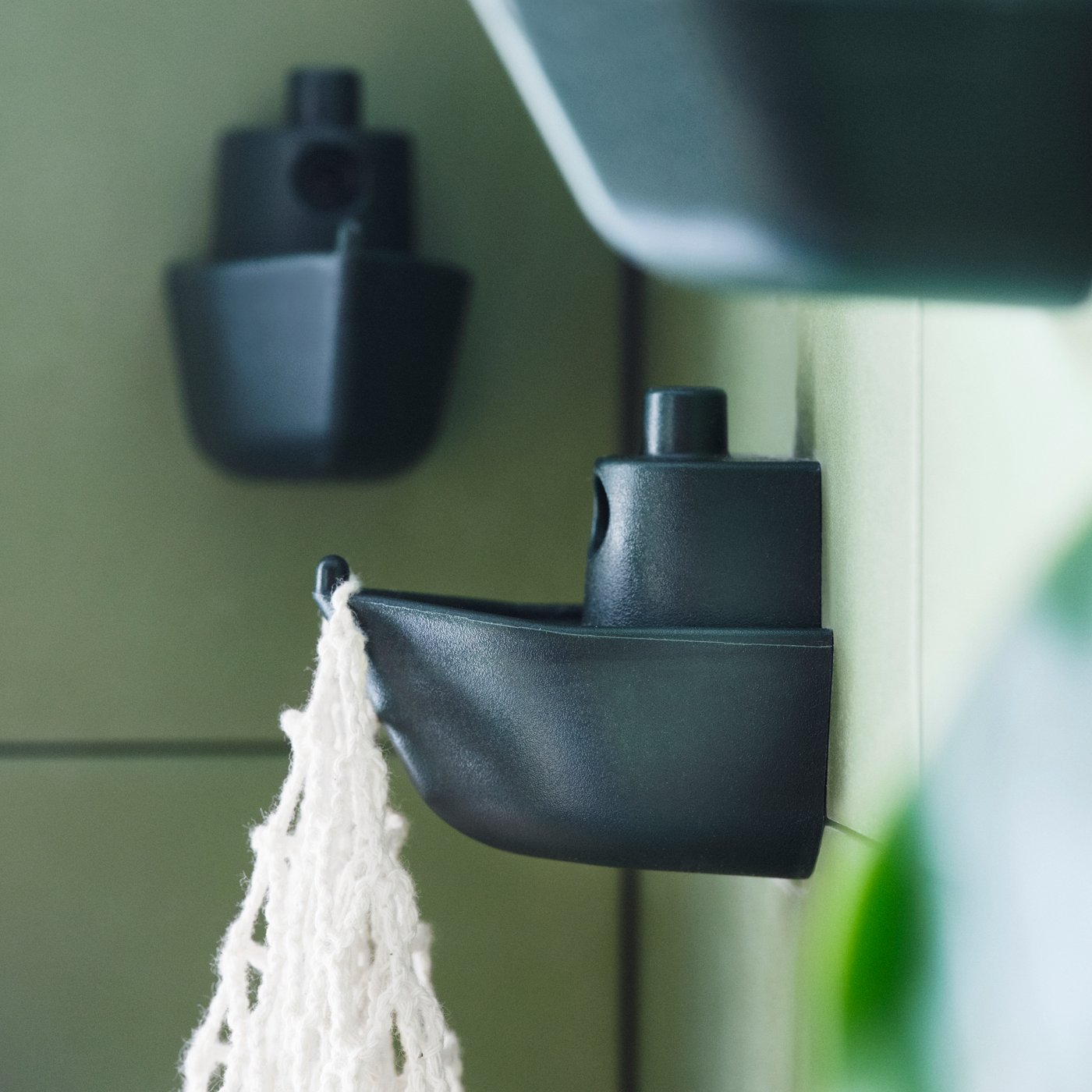 A green KNOPARE hook in the bathroom
