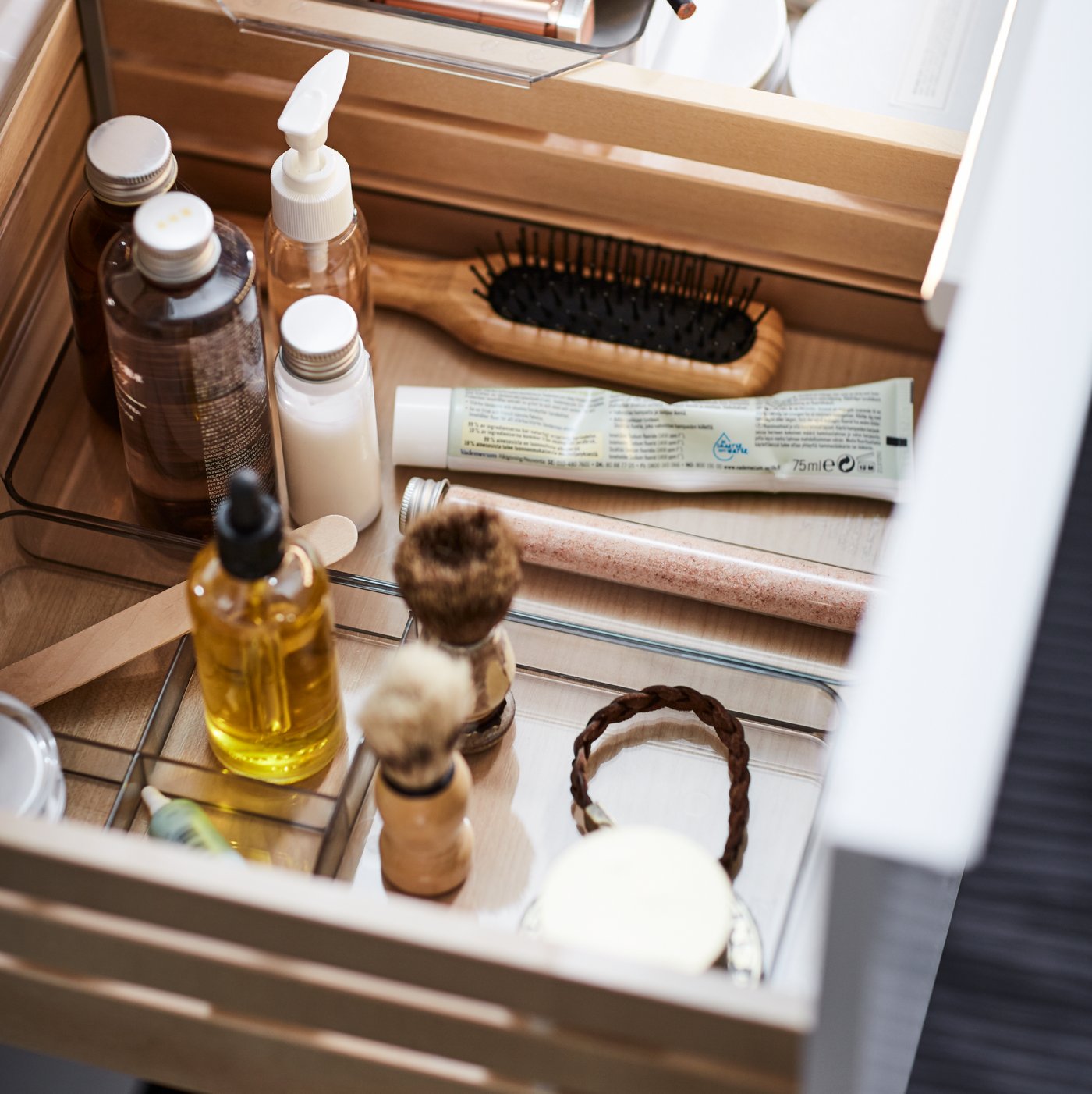 A close-up of an open drawer of the GODMORGON wash-stand, revealing neatly displayed toiletries.