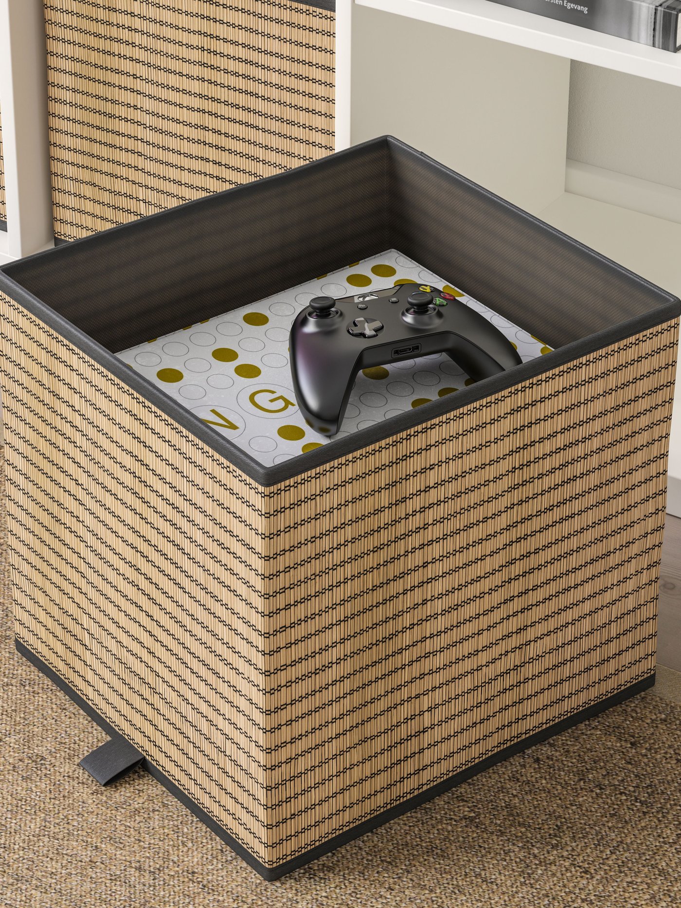 An IKEA GNABBAS storage box with a console remote inside.