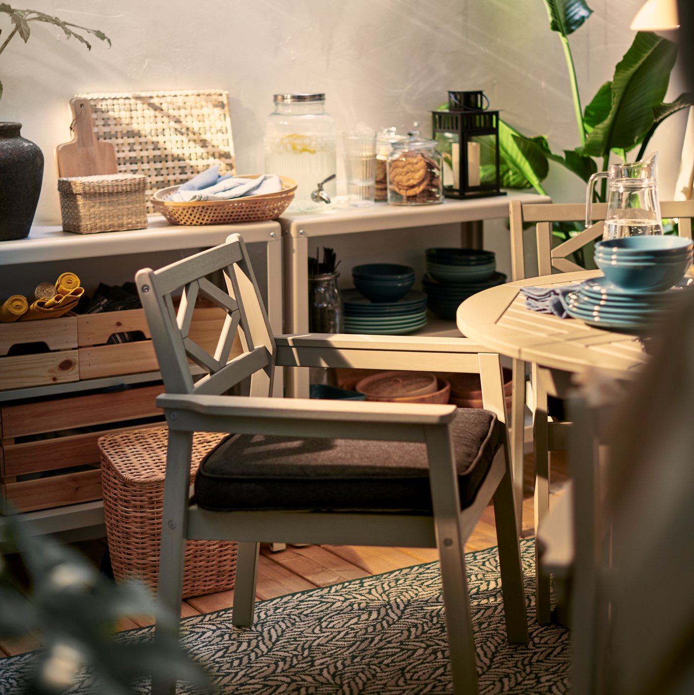 La esquina de un patio con una silla de terreza BONDHOLMEN rug flatwoven sobre una alfombra de terraza SKELUND.